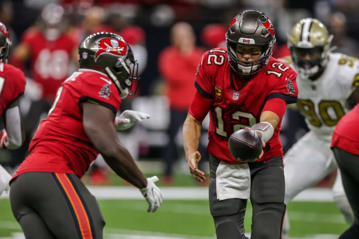 Buccaneers quarterback Tom Brady (12) hands the ball off to Leonard Fournette (7) against New Orleans. Mandatory Credit: Stephen Lew-USA TODAY